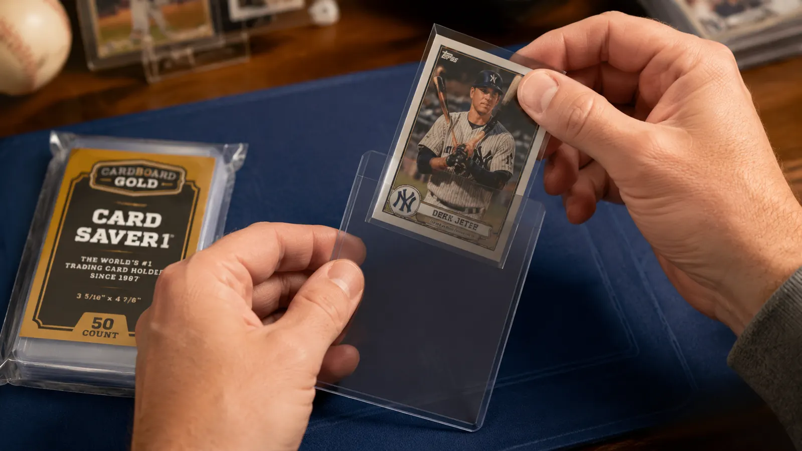 Hand sliding a sleeved baseball card into a Card Saver 1 semi-rigid holder over a light sorting mat