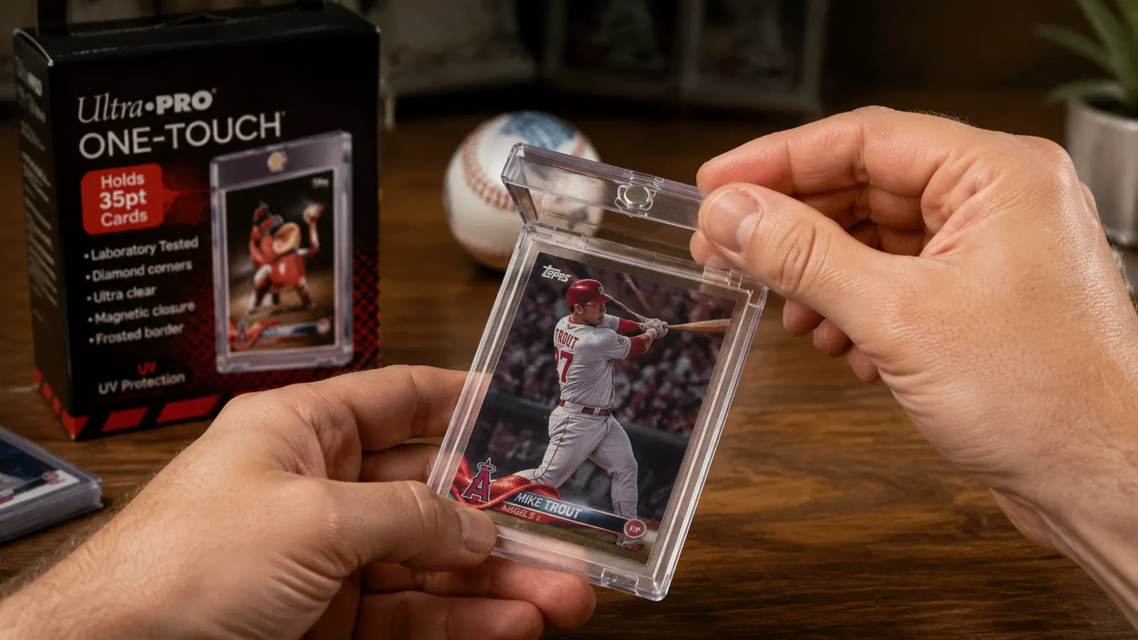 Hands pressing the top half of an Ultra Pro One Touch magnetic holder closed over a sleeved baseball card